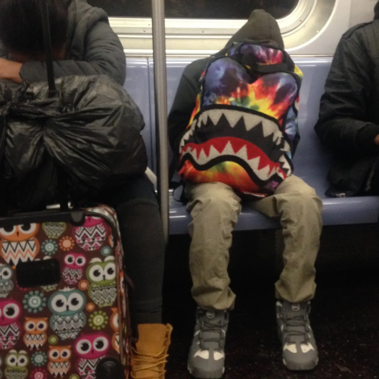 A Sprayground shark-mouth backpack on a New York subway train